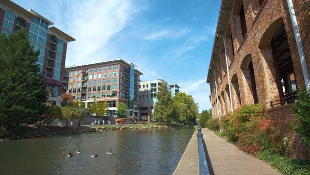 Downtown of Greenville city in South Carolina. View of the Wyche Pavilion, old brick factory on Reedy River and apartment buildings. American travel destination.