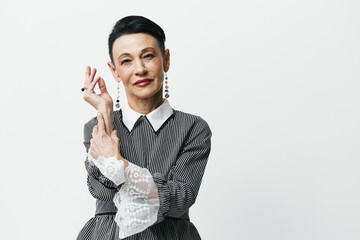 Portrait of an Asian woman posing with hands in front of her face in a stylish and confident manner...
