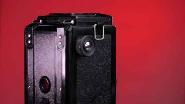 close-up vintage, old photo camera rotates on a red, pink background