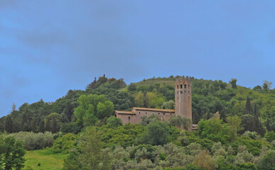 Fototapeta na wymiar Former monastry La Badia in the green Umbrian hills in Orvieto, Italy, with blue clouded sky