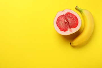 Banana and half of grapefruit on yellow background, flat lay with space for text. Sex concept