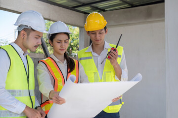 Civil engineer teams meeting working together wear worker helmets hardhat on construction site in...