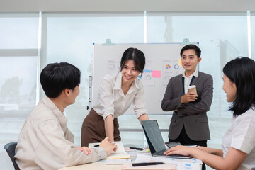 Fototapeta premium team of Asian businessmen meets to brainstorm ideas about office work management in an office conference room.