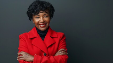 Portrait of handsome smiling 40 year old female business woman wearing a red jacket with folded arms
