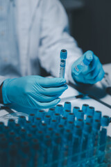 Many test tubes were analyzed by experts, A researcher is carefully studying the liquid contained...