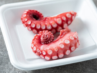Boiled octopus legs in a packaging container © mnimage