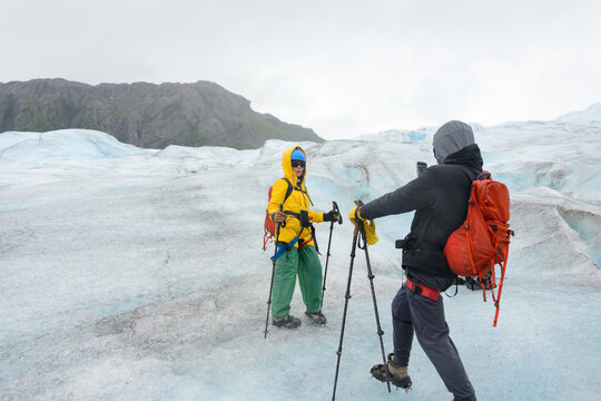 Hiking Exit Glacier. Couple taking photos using smartphones. Kenai Fjords National Park. Alaska.