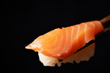 Salmon sushi on chopsticks