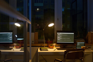 No people interior shot of modern workplace in office with computer and laptop on desk late in...