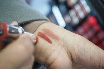 A gesture of applying carmine lipstick to the flesh of another persons hand