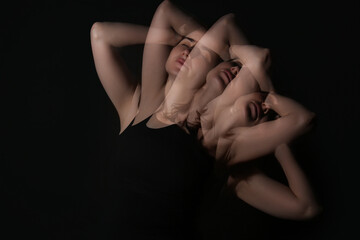 Stroboscopic photo of young woman keeping hands behind head on dark background