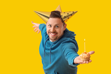 Happy funny man with birthday cake on yellow background