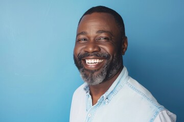 Portrait of Smiling Middle Aged African American Man with Beard Against Blue Background