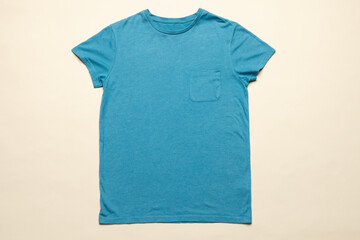 A plain blue t-shirt is laid out flat against a neutral background, with copy space