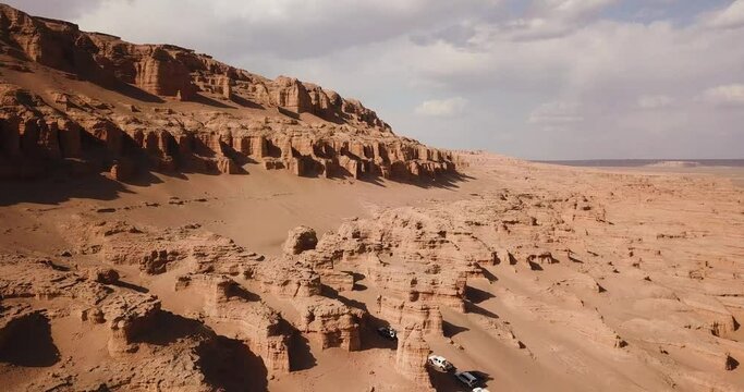 Huge wonderful rock cliff formation kalut in desert climate cloudy weather sand dune background and scenic natural landscape of SUV vehicle off road car adventure traveler in middle east Saudi Iran
