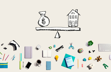 House and money on the scale with collection of electronic gadgets and office supplies