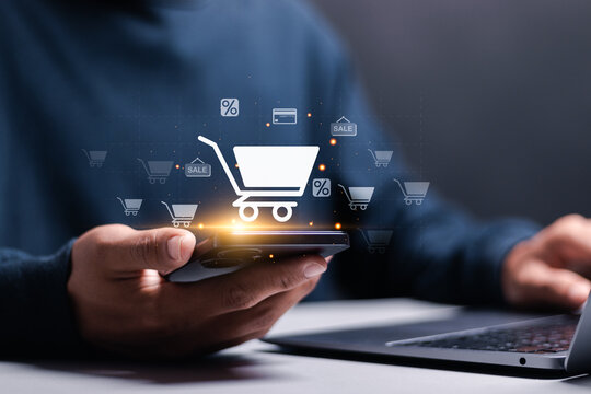 Business ecommerce concept. Person use smartphone and laptop with online shopping cart icon on virtual screen. online purchase, ecommerce store, online business, shopping on the internet.