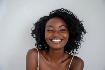 Portrait of a radiant young woman with a beaming smile Posing against a white background Embodying positivity and beauty
