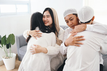 Portrait of Asian muslim family, parents and children hugging and forgive each other at Eid mubarak...
