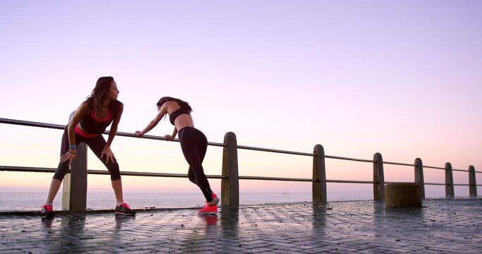 People, sunset or runners at beach stretching for running, exercise or fitness workout in promenade. Friends, wellness or sports athletes resting in training in practice warm up to relax the body