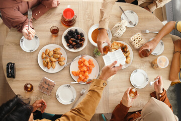 Top view of muslim people enjoy the iftar meal dinner together in dining room. Ramadan Background. 