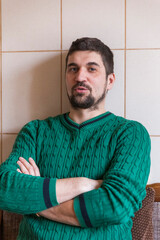 portrait of a handsome young man in a green sweater with a beard