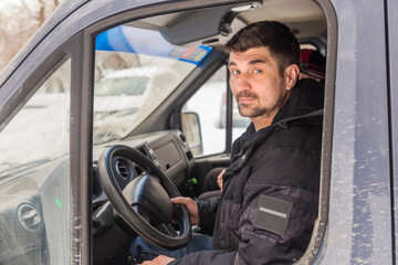 young handsome man driving in the cab of a large truck