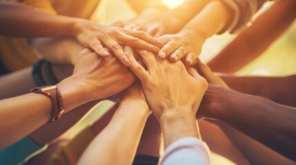A team of people holding hands together in a gesture of unity, friendship, and teamwork, symbolizing care and love within a supportive community.