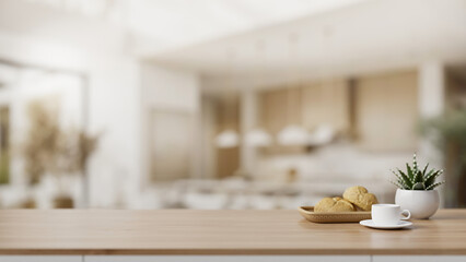 A copy space on a wooden tabletop with a blurred background of a spacious modern, luxury kitchen.