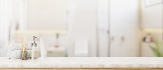 Toiletries and empty space on a white marble tabletop in a modern white and clean bathroom.