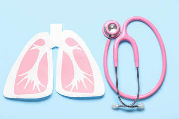 Paper lungs and stethoscope on blue background