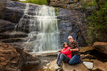 beautiful elderly couple traveling through the mountains of the Southern Urals, Gadelsha waterfall