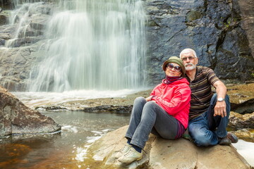 beautiful elderly couple traveling through the mountains of the Southern Urals, Gadelsha waterfall