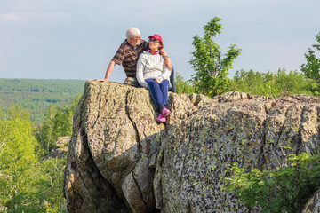 happy mature married couple traveling through the Ural mountains on a summer day