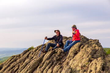 happy mature married couple traveling through the Ural mountains on a summer day