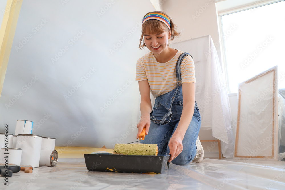 Sticker young woman with paint roller doing repair in room