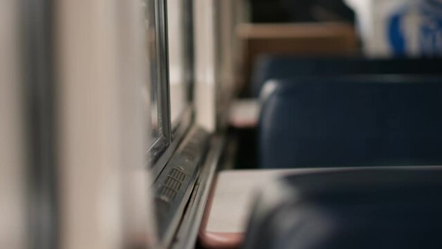Closeup of details of a booth on a train, showing a moment of the passenger rail experience in the United States. The edge of a table is in focus, as are the shapes of chairs and the train interior.