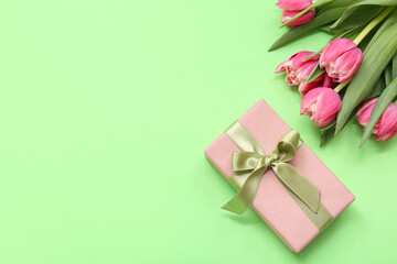 Gift box and bouquet of beautiful tulips on green background. International Women's Day
