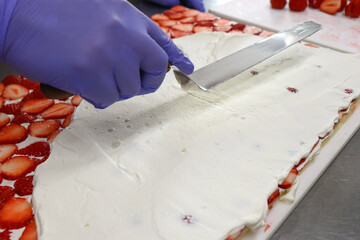 パティシエの厨房、イチゴの上にクリームを塗る、デコレーションケーキ