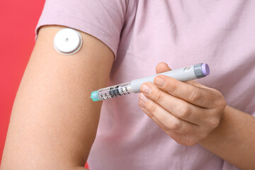 Woman with lancet pen and glucose sensor, closeup. Diabetes concept