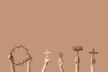 Female hands with crown of thorns, crosses, nails and mallet on color background. Good Friday...
