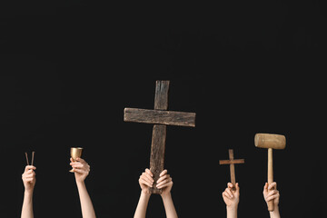 Female hands with wooden crosses, mallet, cup and nails on dark background. Good Friday concept