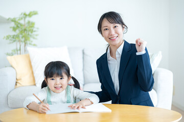 部屋で子供に勉強を教えるスーツを着た女性
