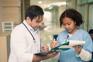 Obraz premium American doctor working in hospital, Team doctor discussion report on folder medicine, profession and healthcare concept