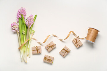 Hyacinth flowers, ribbon and gift boxes on white background. Top view