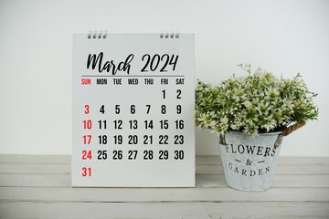 March 2024 monthly calendar with vintage alarm clock on wooden background