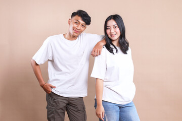 Asian man and woman couple wearing white t-shirt for mockup on beige background. - Powered by Adobe