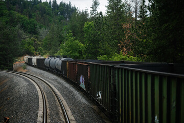 A long train with a mixed manifest of boxcars and tankcars, showing freight of goods such as fossil...