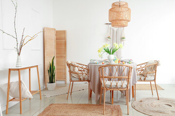 Light interior of festive decorated dining room with Easter table setting, lamp and chairs