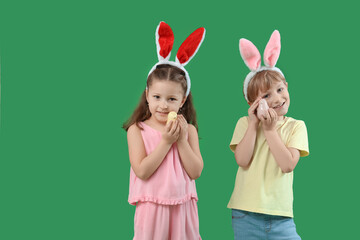 Cute little children in bunny ears with birds on green background. Easter celebration